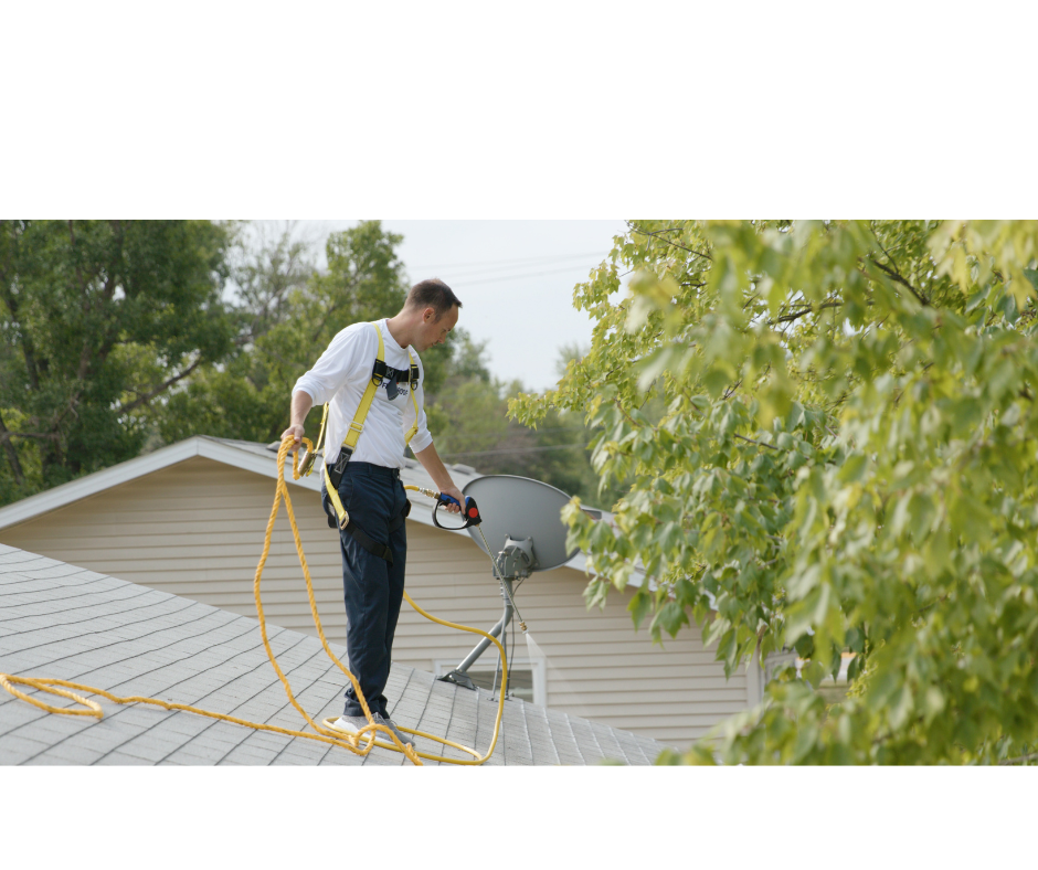 Green Valley technician in safety harness applying roof rejuvenation treatment on a Quiet Corner home